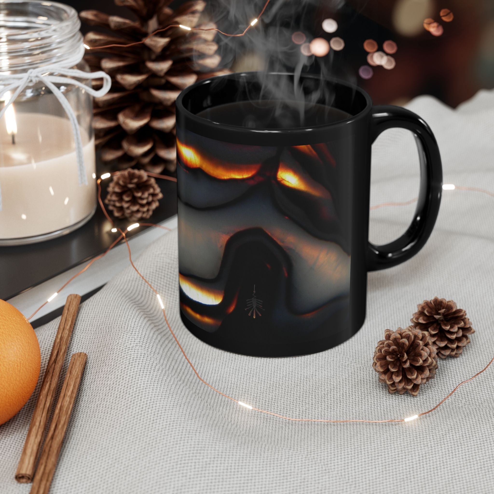 Black mug with a fiery design on a table with decorative items