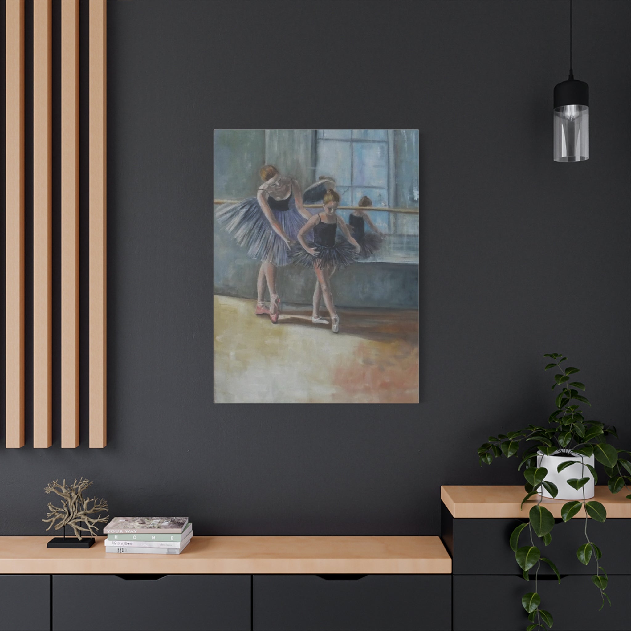 Art print of ballerinas in a dance studio on a dark wall with a wooden console table below.