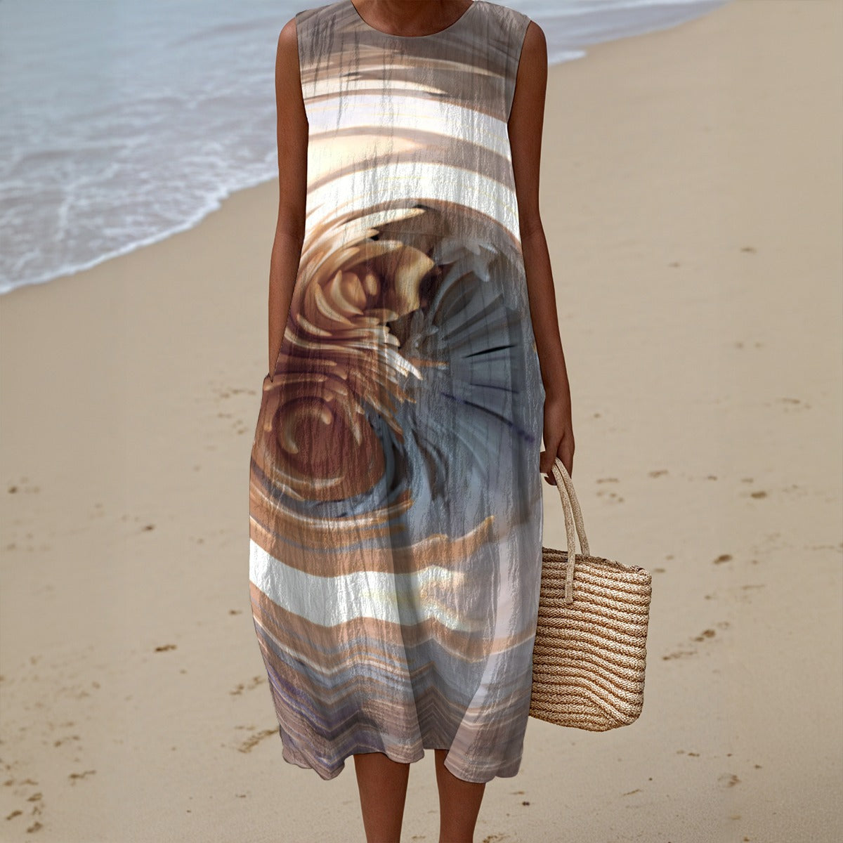 Woman in a sleeveless dress with a beach pattern on a sandy beach.