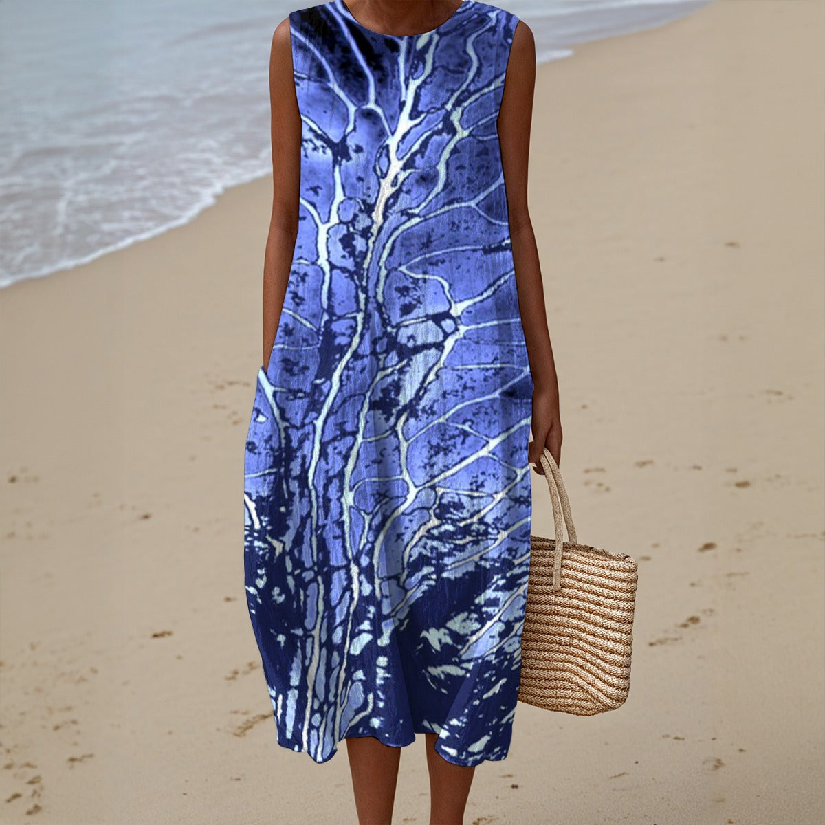 Person wearing a blue patterned dress on a beach