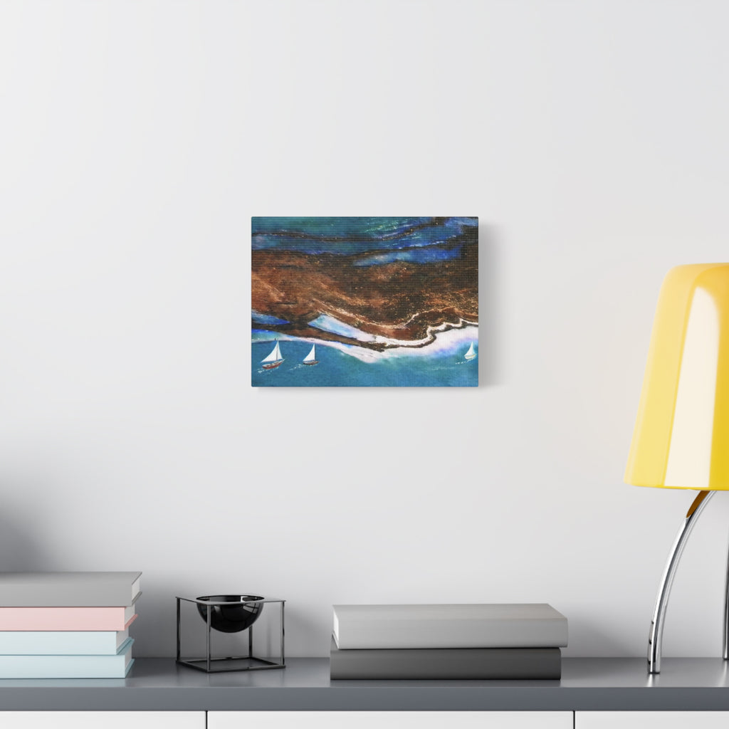 Abstract painting on a wall above a desk with books and a lamp.