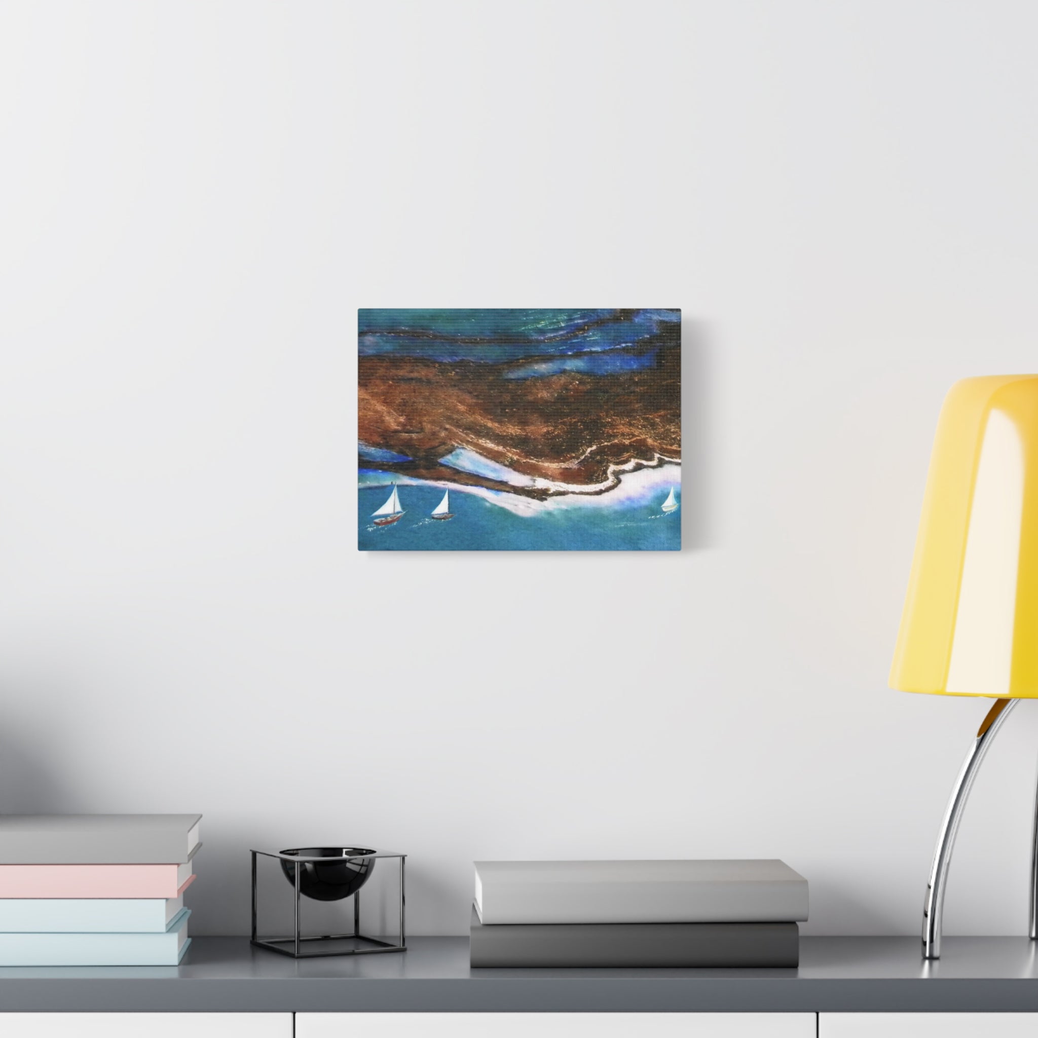 Abstract painting on a wall above a desk with books and a lamp.