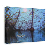 Canvas print of a bird flying over water with tree reflections at dusk.