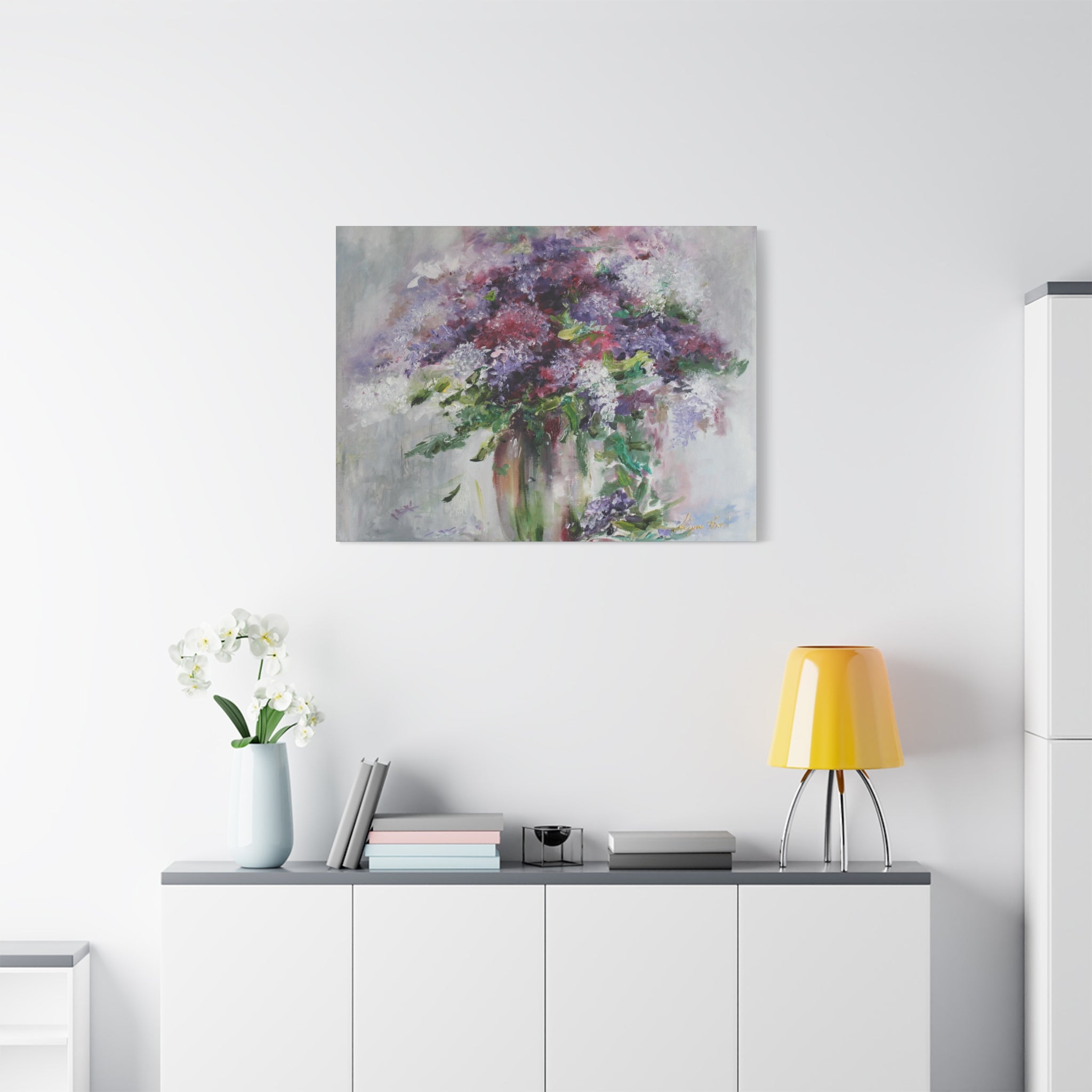 Floral painting on a wall above a white cabinet with decorative items.
