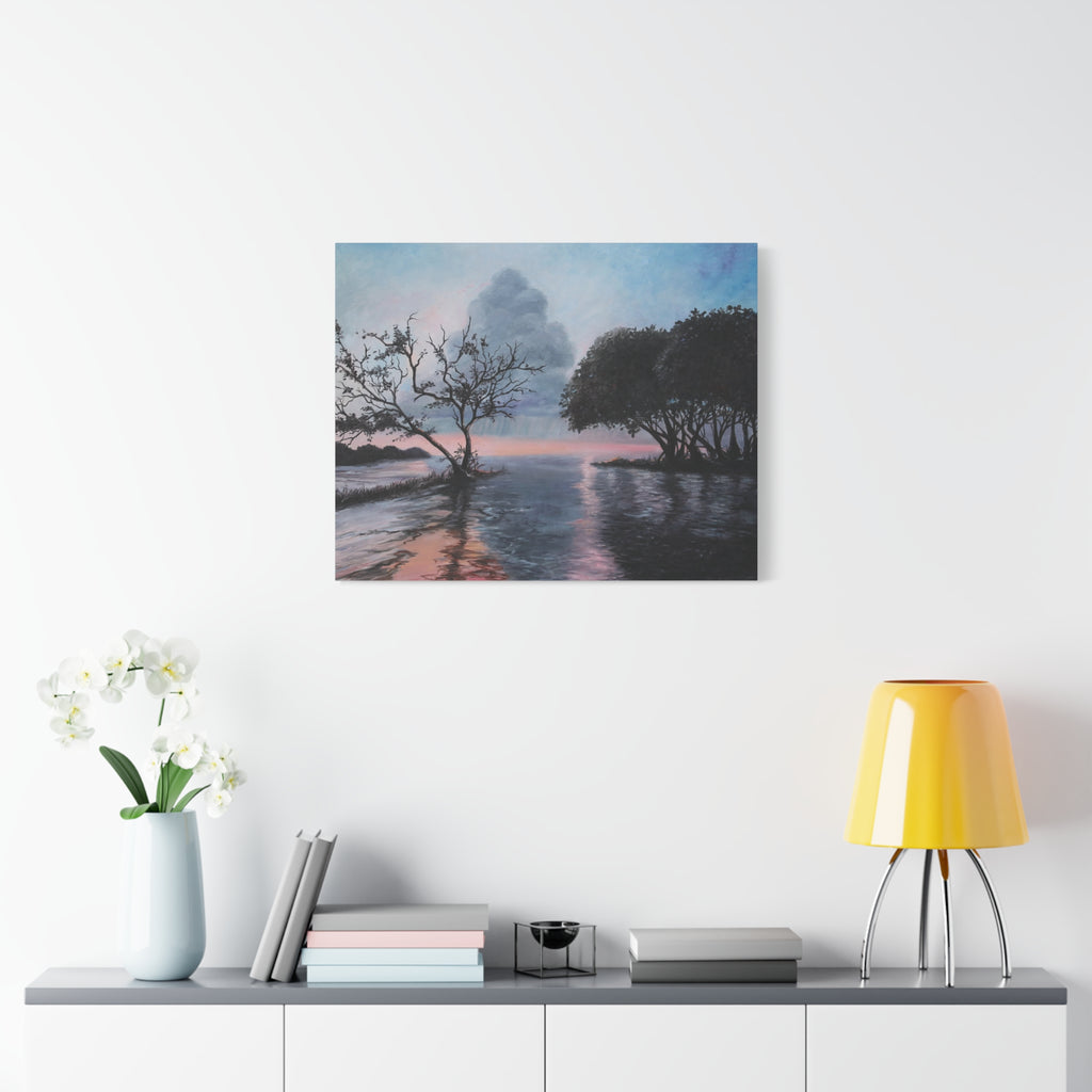 Framed artwork of a landscape with trees and water on a wall above a shelf with decor items.