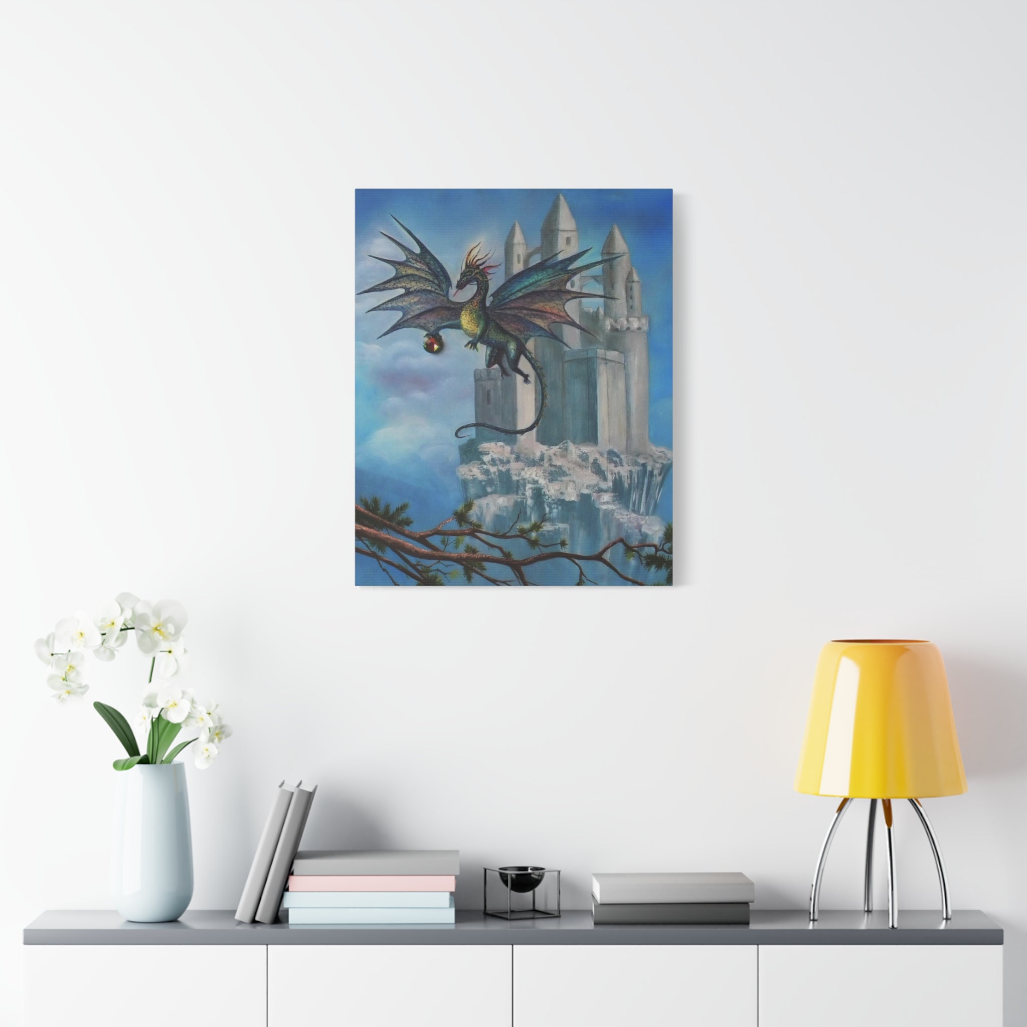 Framed artwork of a dragon flying over a castle on a white wall above a shelf with decor items.