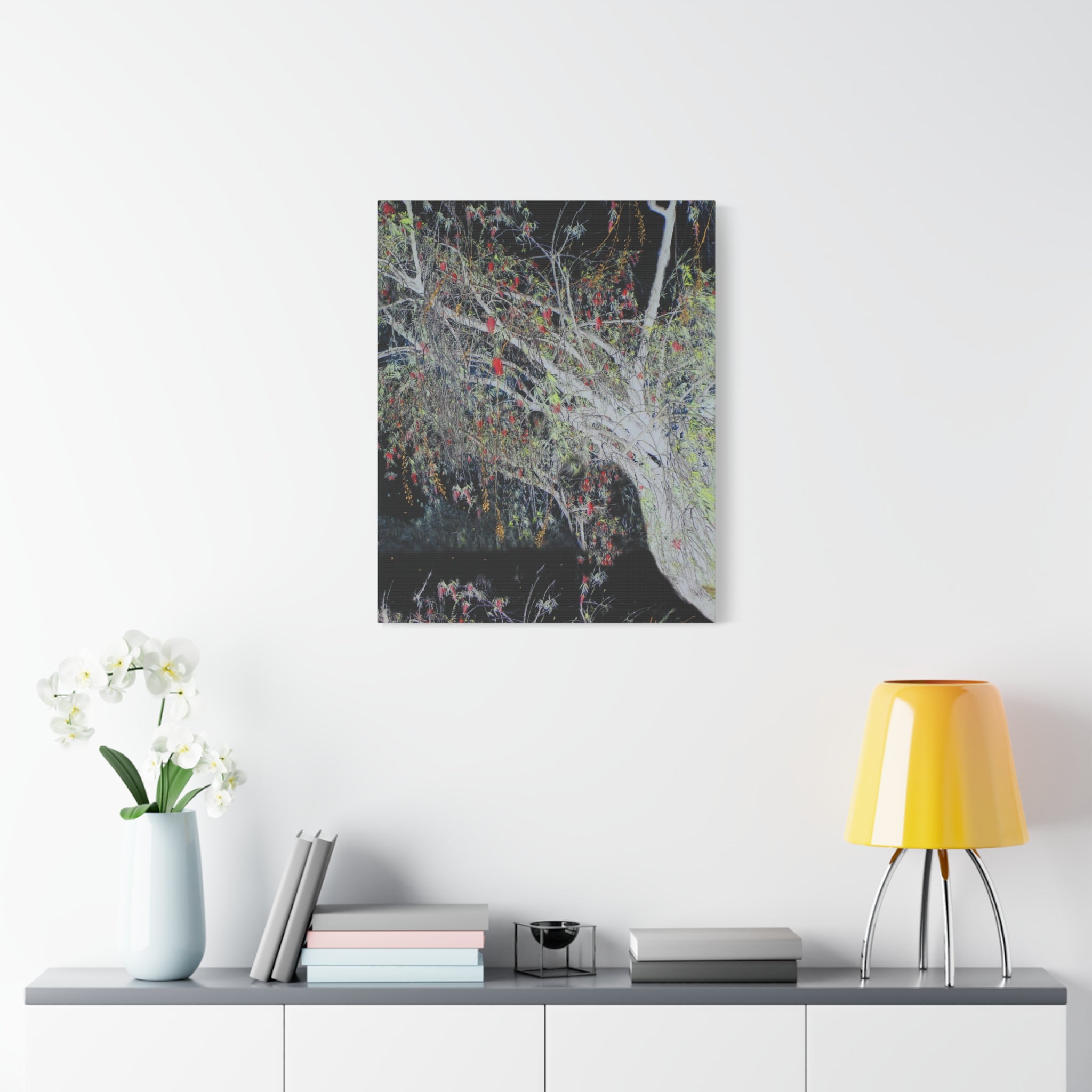 Canvas print of a tree with colorful leaves on a white wall above a shelf with decor items.