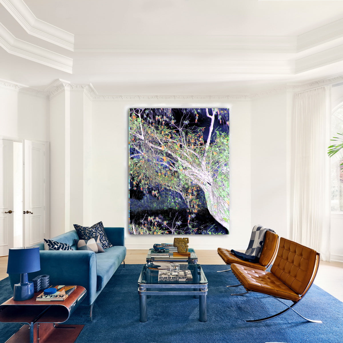 Modern living room with blue sofa, brown chair, and large abstract painting on white wall.