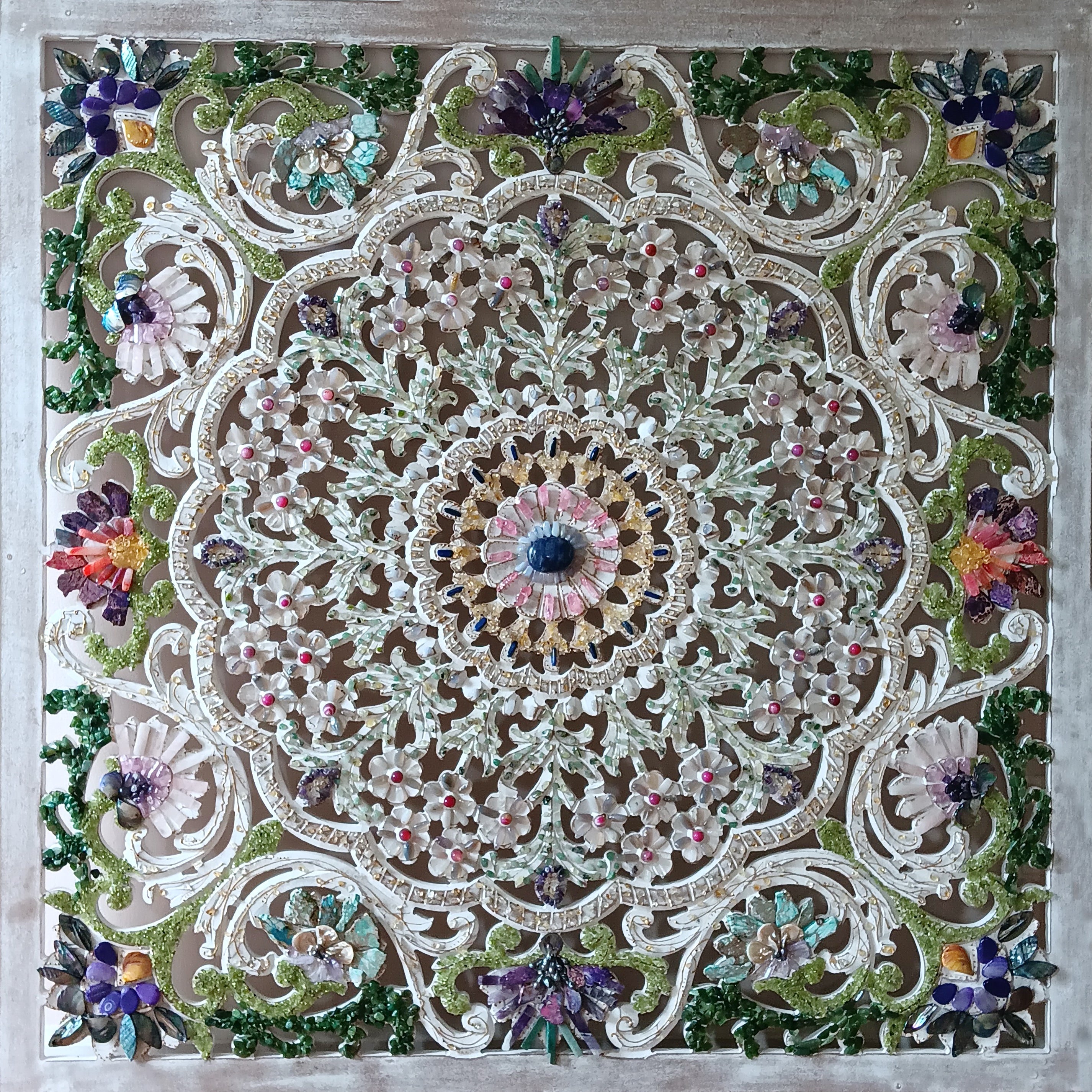 Decorative mosaic with floral patterns and a central design on a wooden frame.